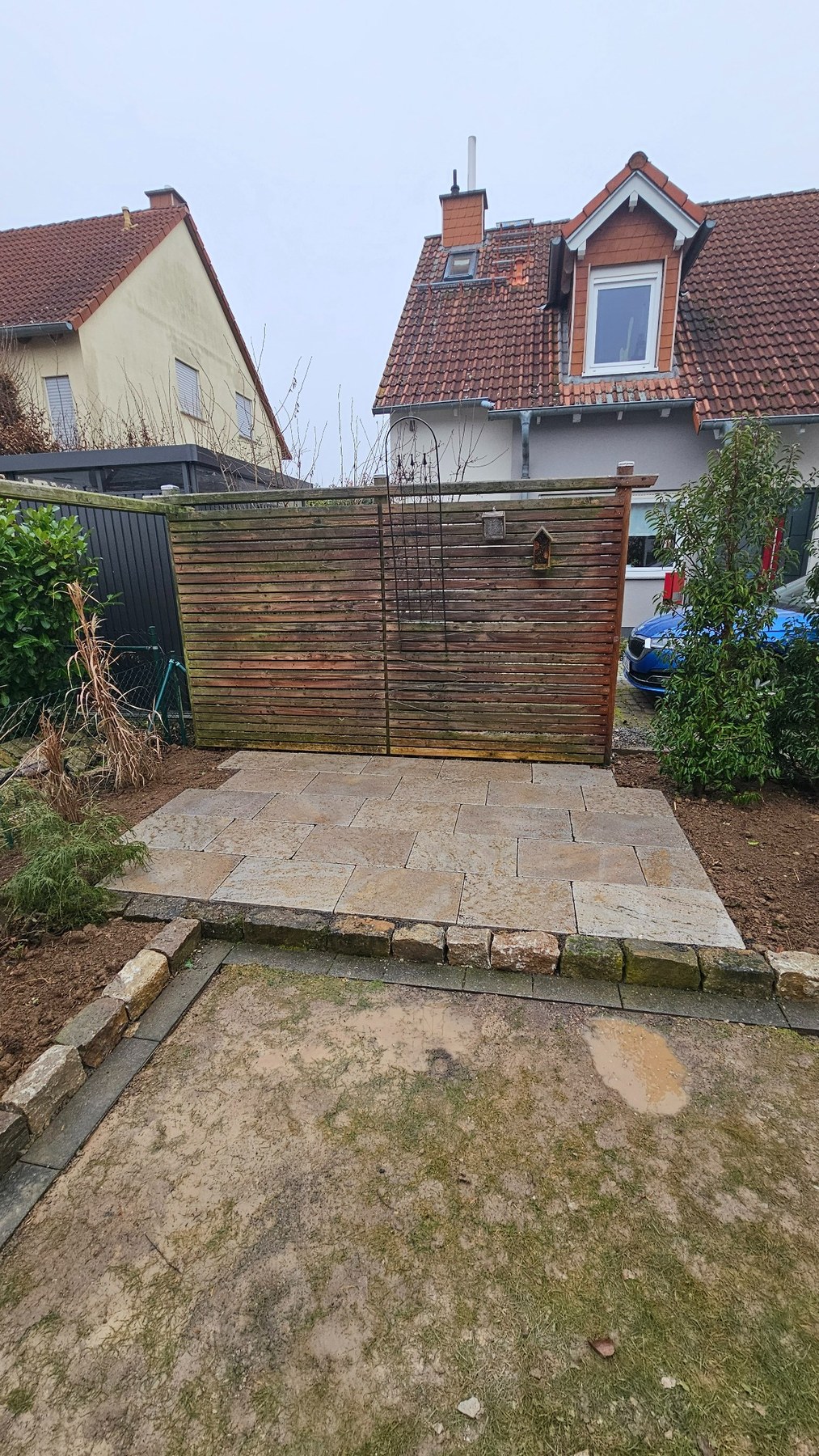 Gartengestaltung mit Natursteinfläche und Pflanzbeeten in Mainz